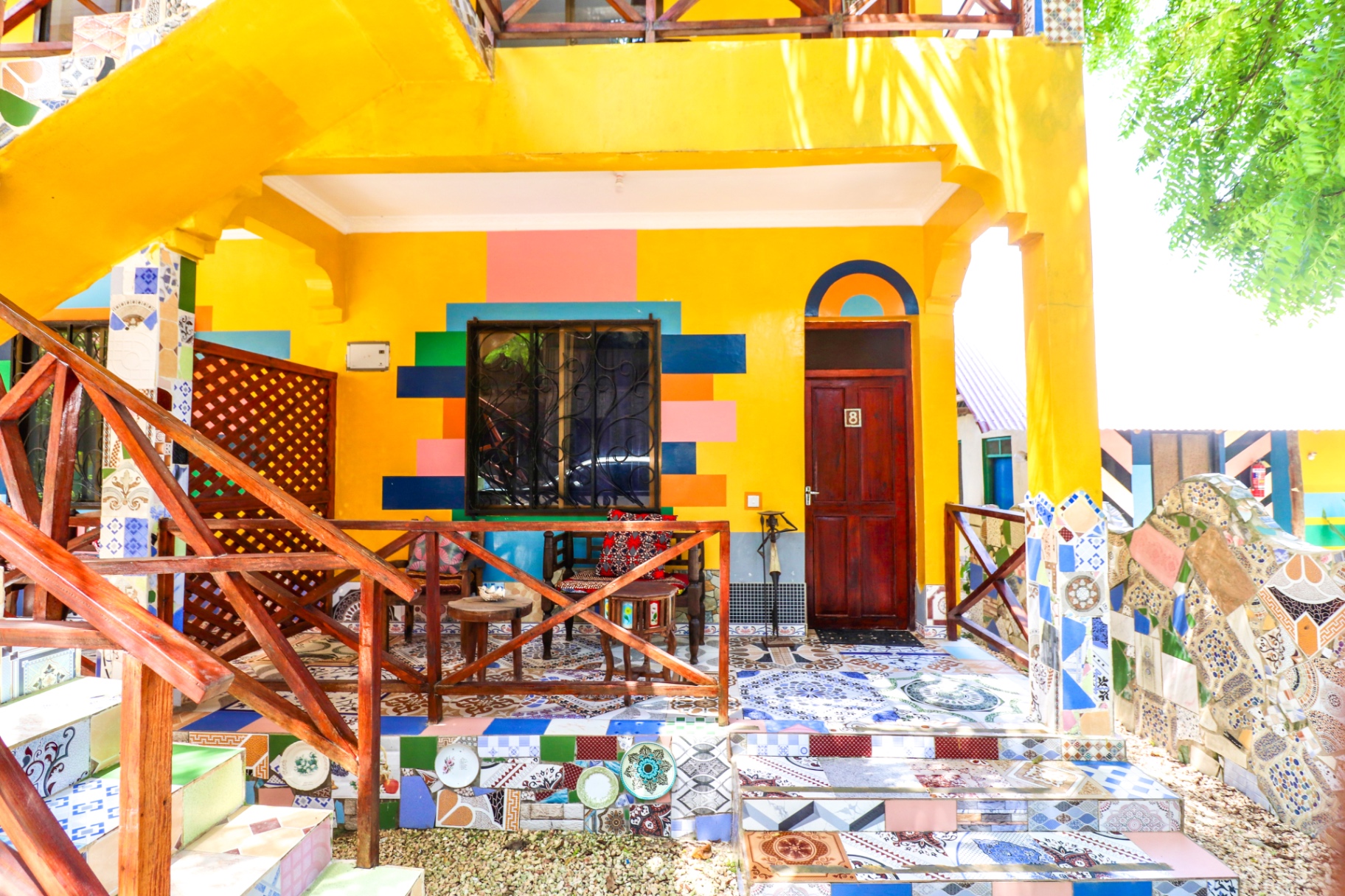 Vibrant yellow bungalow exterior with mosaic tiles